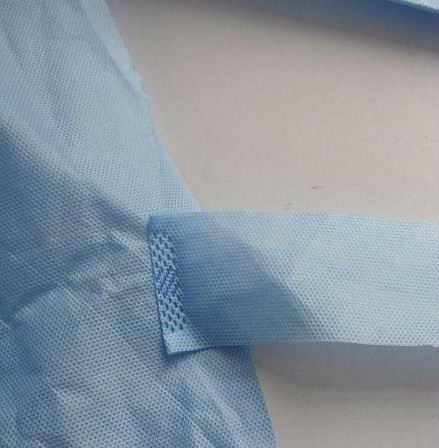 Το μη απορροφητικό μίας χρήσης νοσοκομείο τρίβει την εσθήτα εργαστηρίων με την πλεκτή μανσέτα